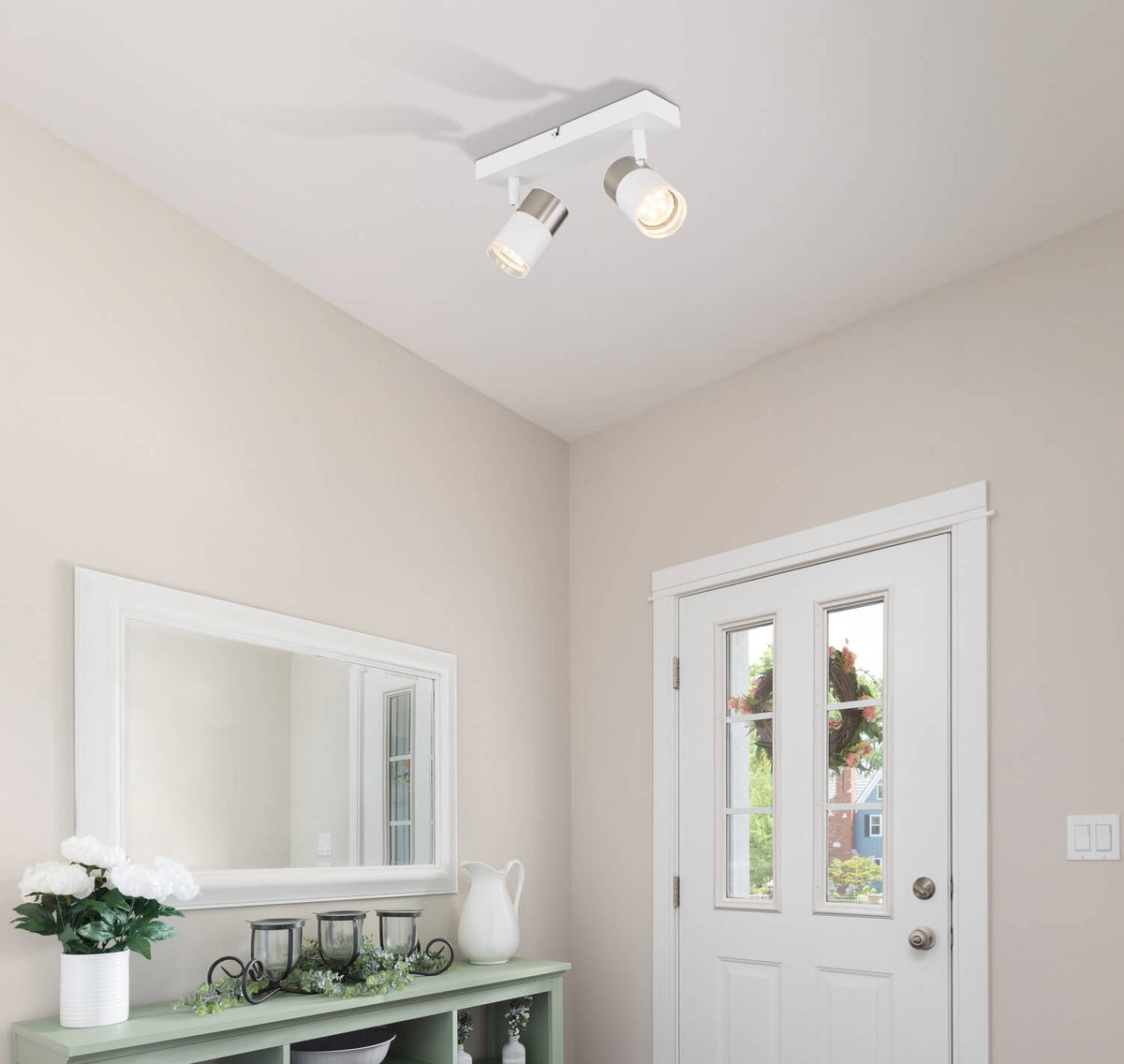 Mise en ambiance du spot au plafond d'une entrée avec miroir et meuble vert