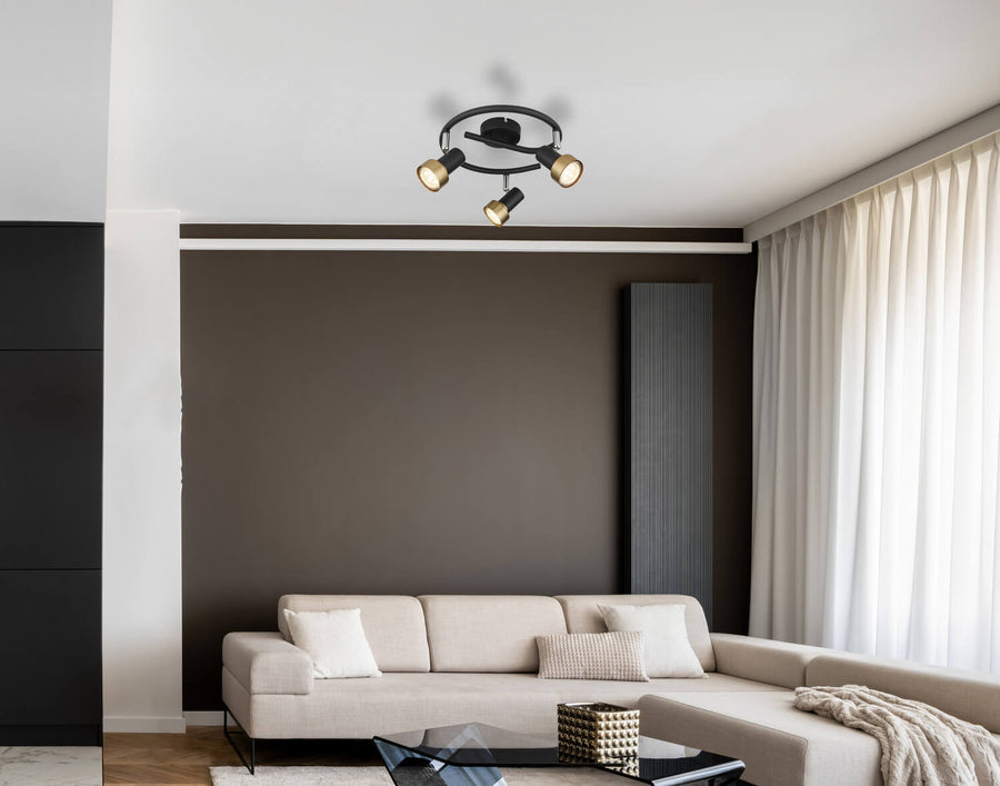Plafonnier installé au plafond dans un salon contemporain, au-dessus d'un canapé beige et d'une table basse.