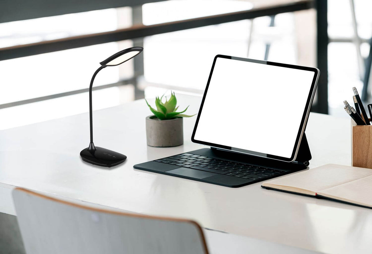 Mise en ambiance de la lampe sur un bureau blanc avec ordinateur et plante.