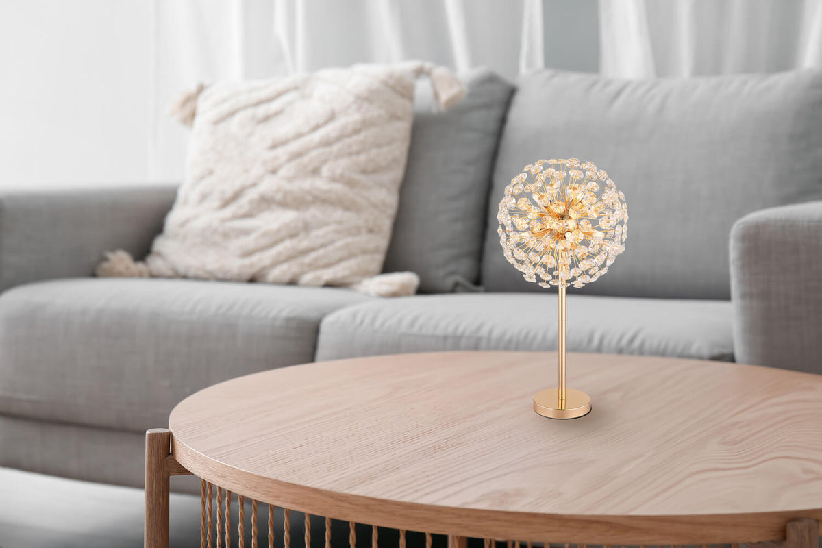 Mise en ambiance : lampe allumée posée sur une table basse devant un canapé gris