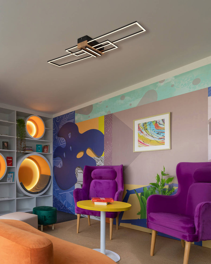 Plafonnier installé au plafond dans un salon coloré avec fauteuils violets et décor mural