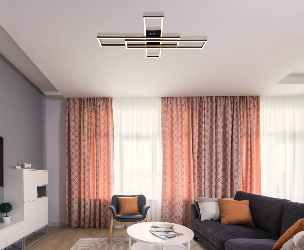 Mise en ambiance dans un salon, plafonnier allumé fixé au plafond au-dessus du canapé