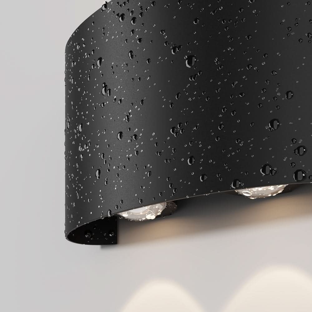Détail du luminaire noir couvert de gouttes d'eau, résistance aux intempéries.