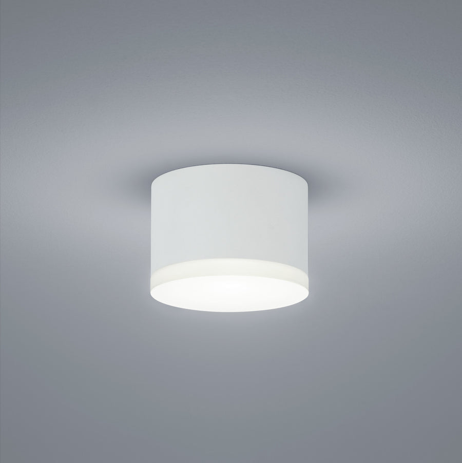 Plafonnier cylindrique blanc vu de dessous, fixé au plafond, lumière diffusée vers le bas.