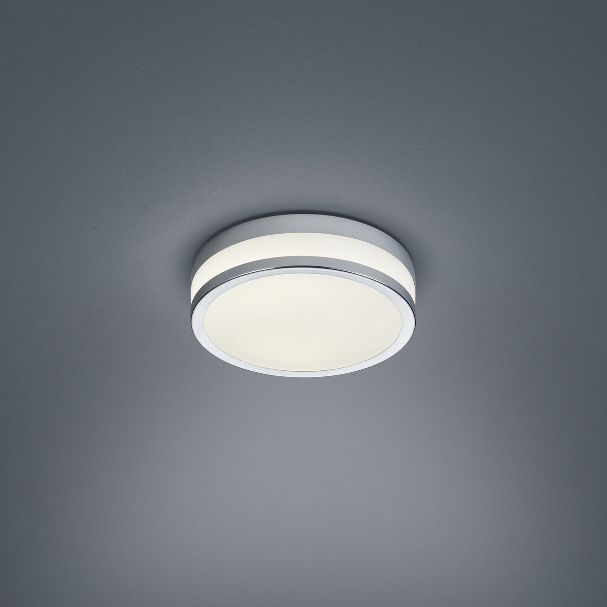 Vue de face du plafonnier rond, cerclage chromé et diffuseur blanc lumineux