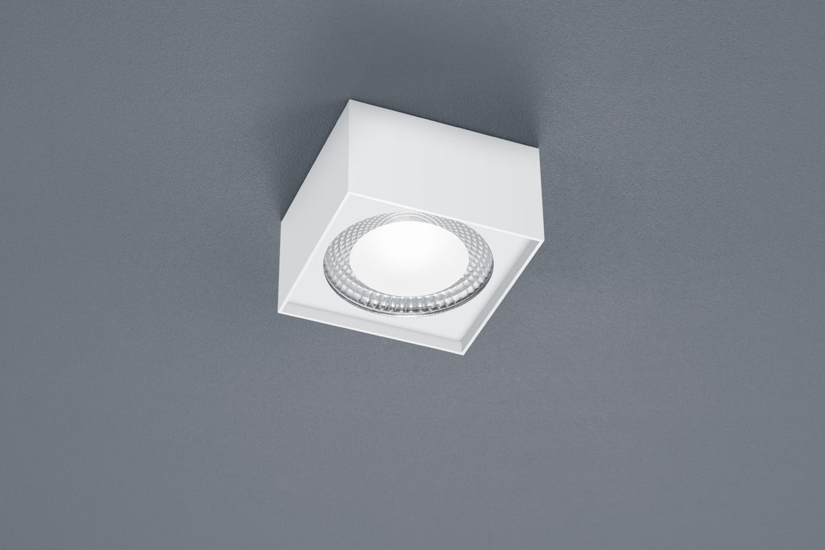 Vue rapprochée du plafonnier blanc carré et de son verre strié.