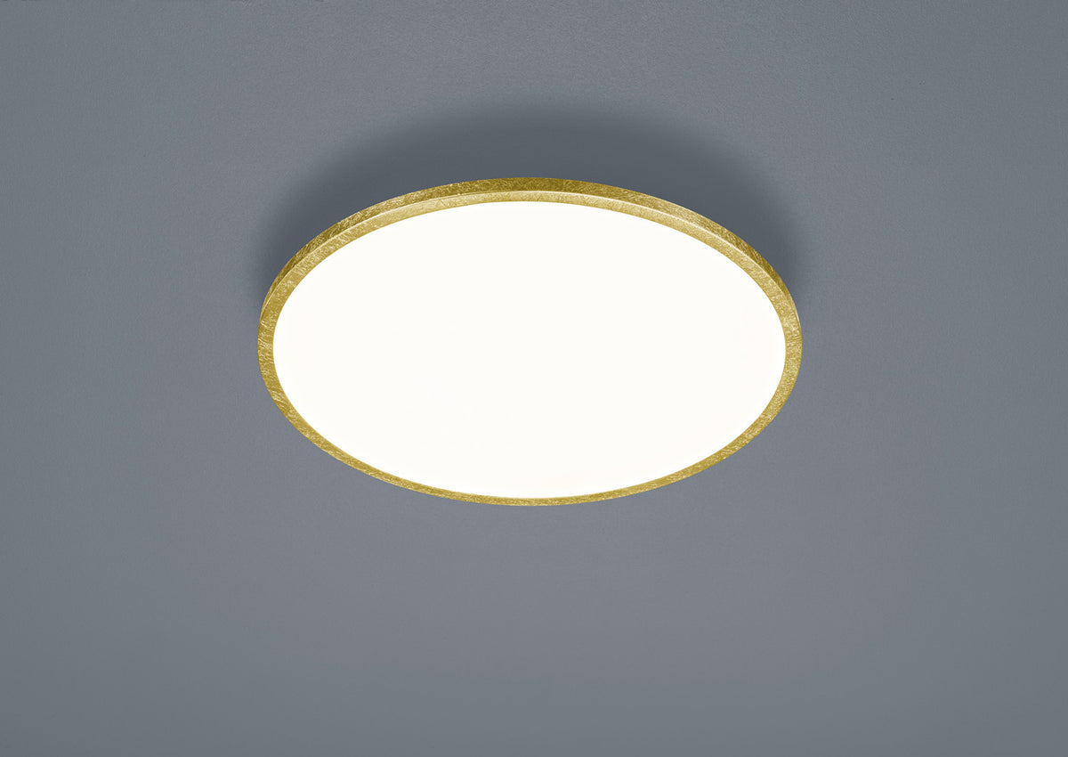 Vue rapprochée du plafonnier doré, détail de la monture et du diffuseur blanc.