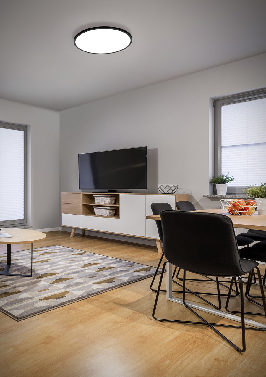 Plafonnier fixé au plafond d'un séjour moderne avec meuble, table et télévision