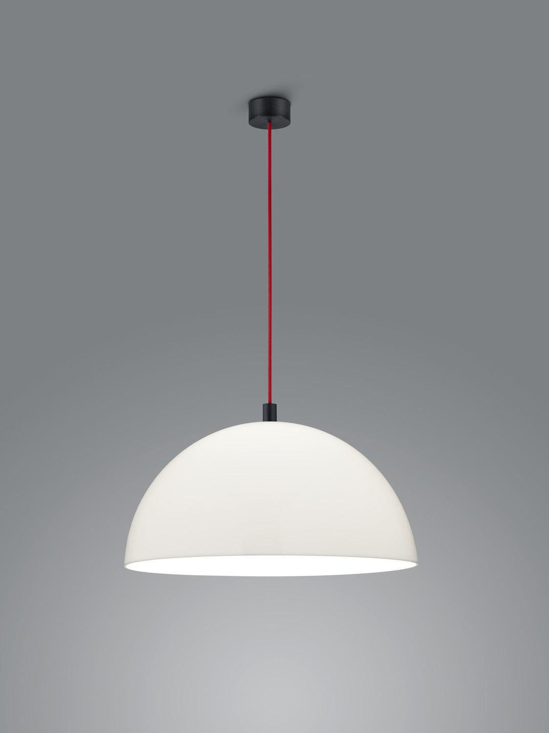 Vue rapprochée du luminaire suspendu blanc, abat-jour bombé et câble rouge.