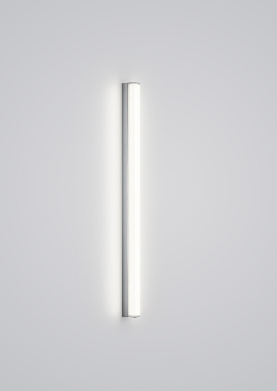 Vue de face d'un tube lumineux vertical blanc isolé sur fond gris clair.