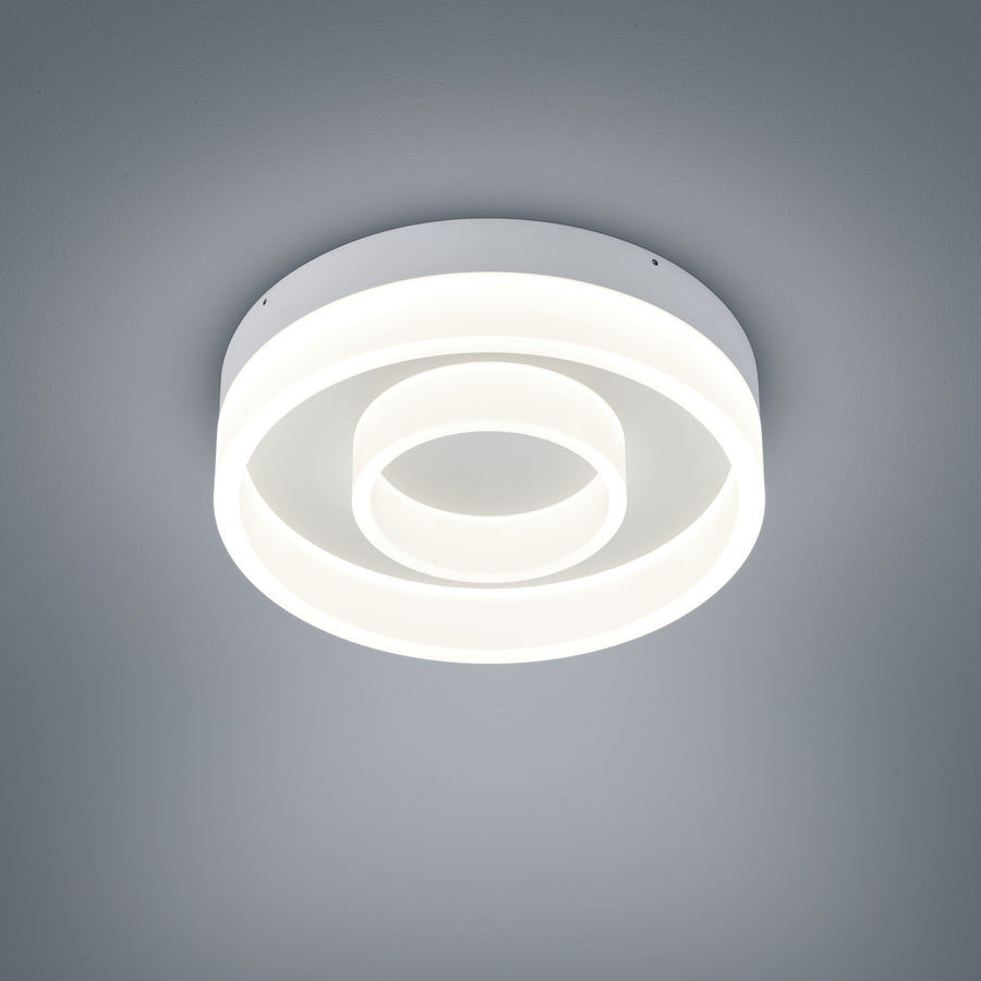 Plafonnier blanc vu de face sur fond gris, anneaux lumineux concentriques