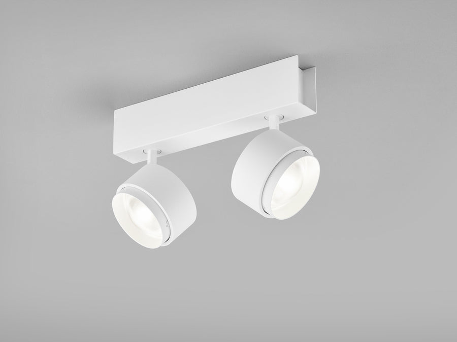 Plafonnier blanc à deux spots cylindriques orientables, vue de face sur fond gris