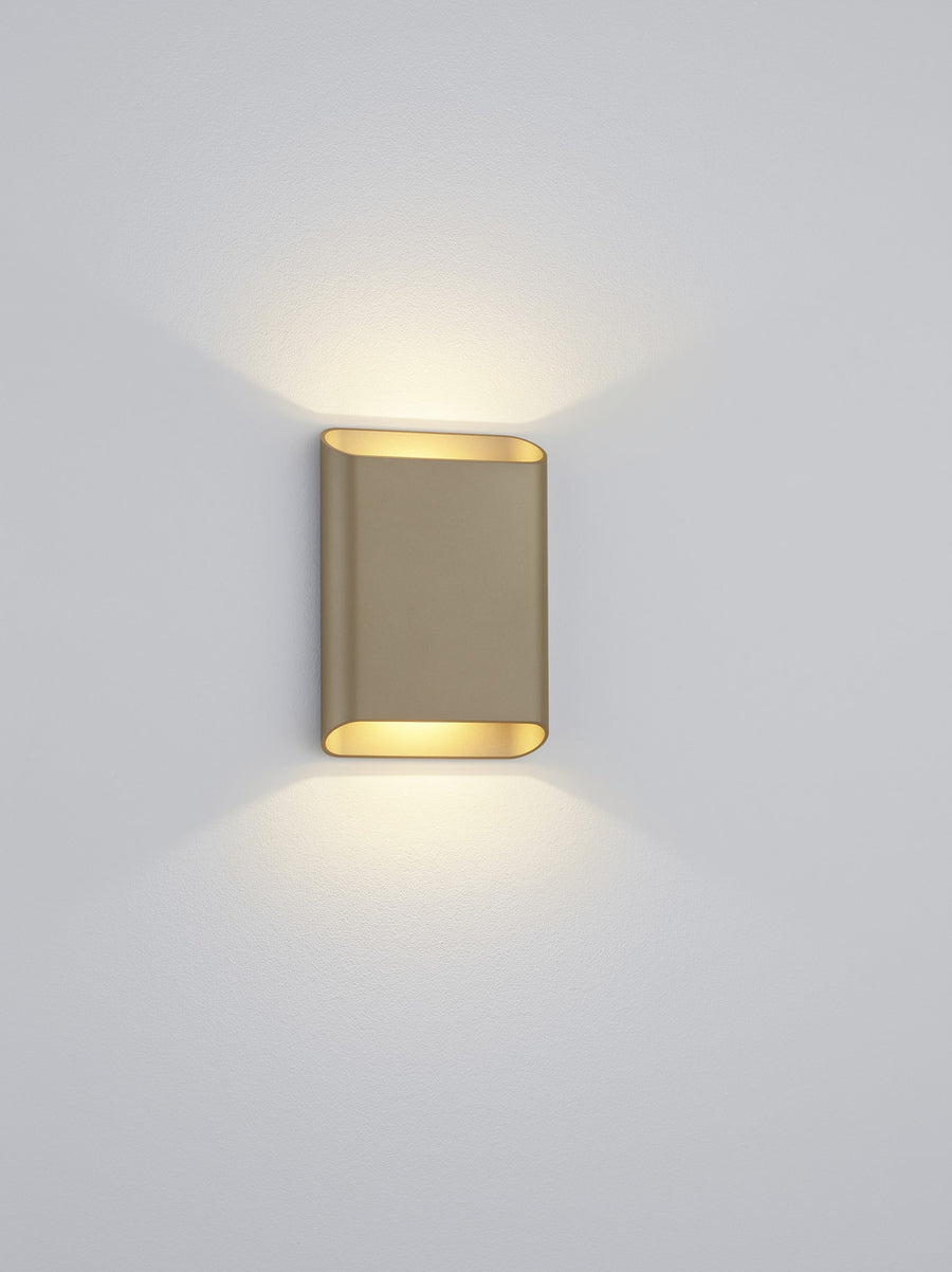 Plan rapproché du boîtier rectangulaire fixé au mur, finition taupe et intérieur doré