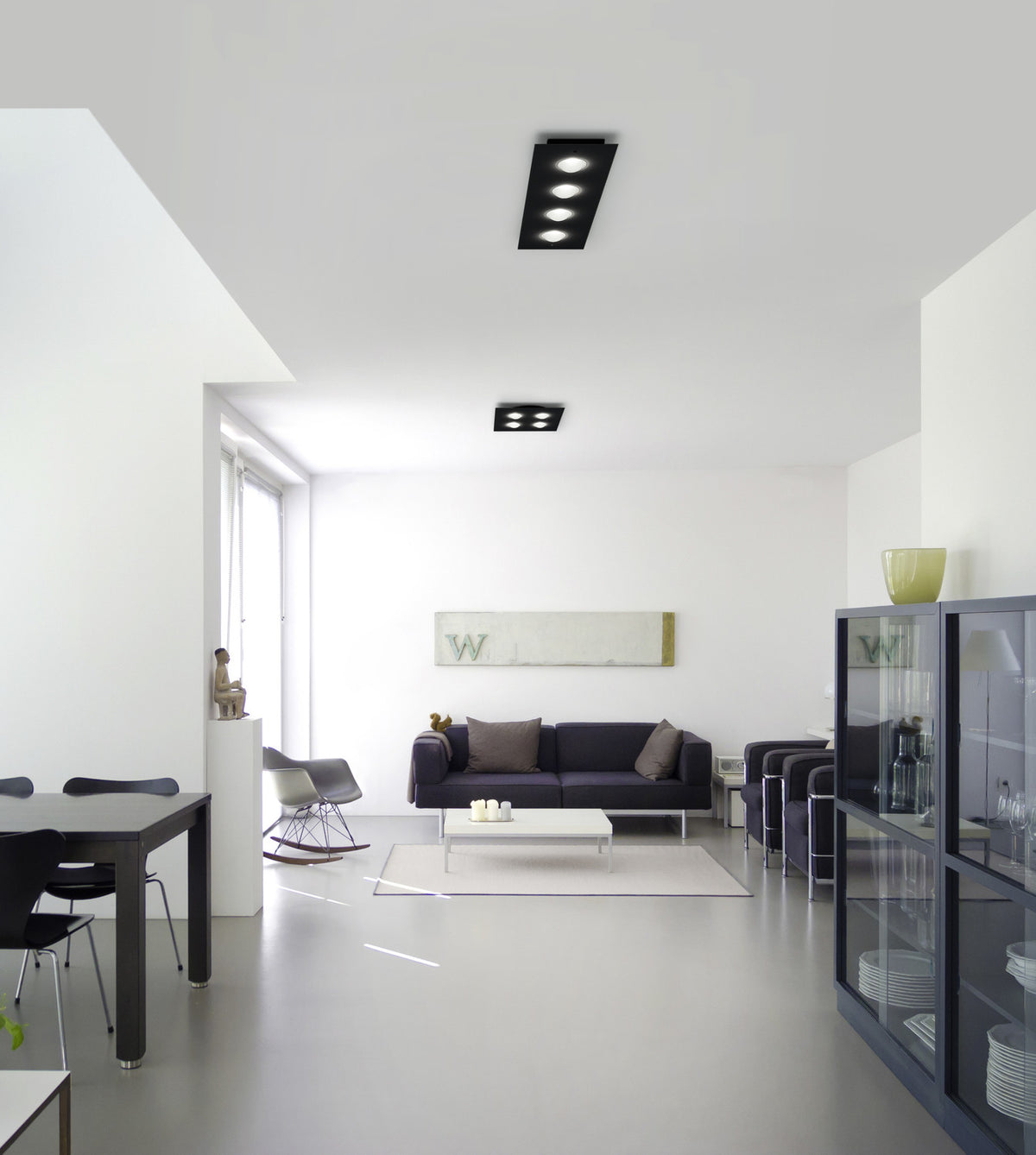 Mise en ambiance d'un séjour blanc minimaliste avec deux plafonniers noirs fixés au plafond