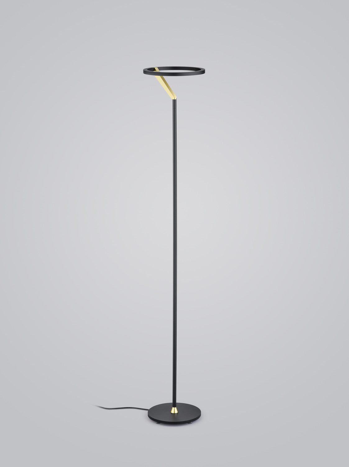 Vue en pied du lampadaire noir, anneau lumineux supérieur et câble au sol.