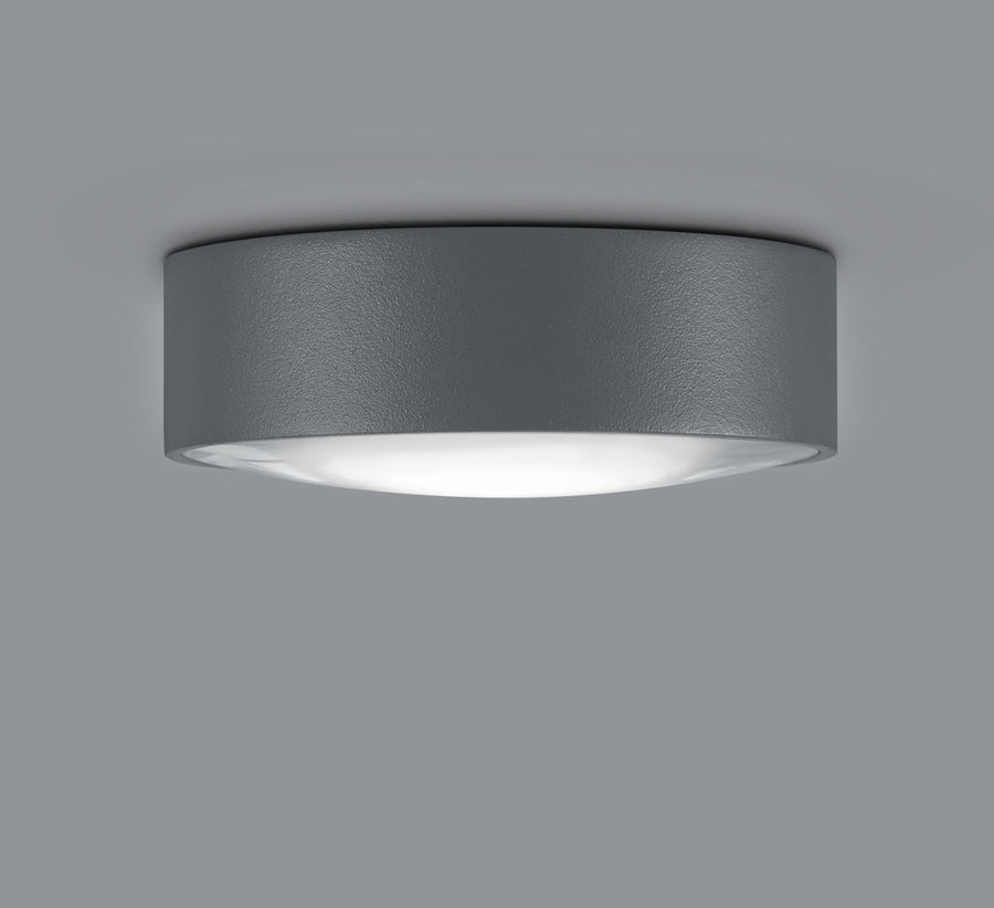 Plafonnier rond anthracite texturé vu de biais, diffuseur blanc allumé sous la coupelle