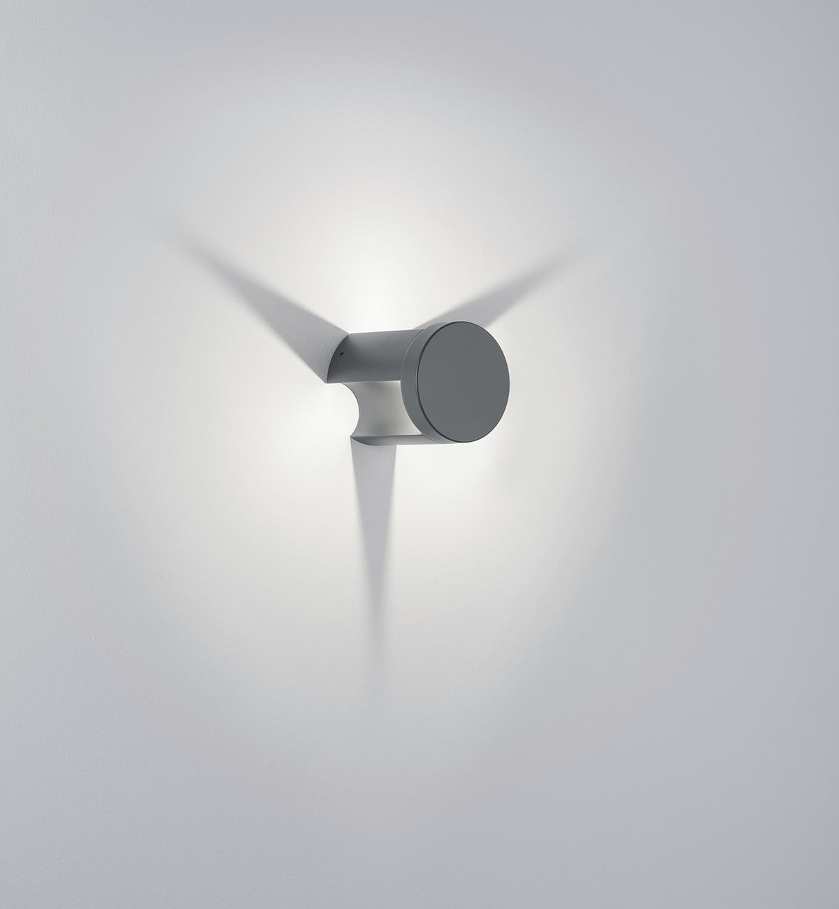 Profil rapproché de l'applique murale cylindrique grise avec faisceau lumineux