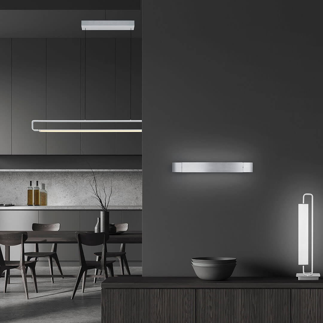 Mise en ambiance dans une cuisine moderne sombre, lampe posée sur un meuble bas