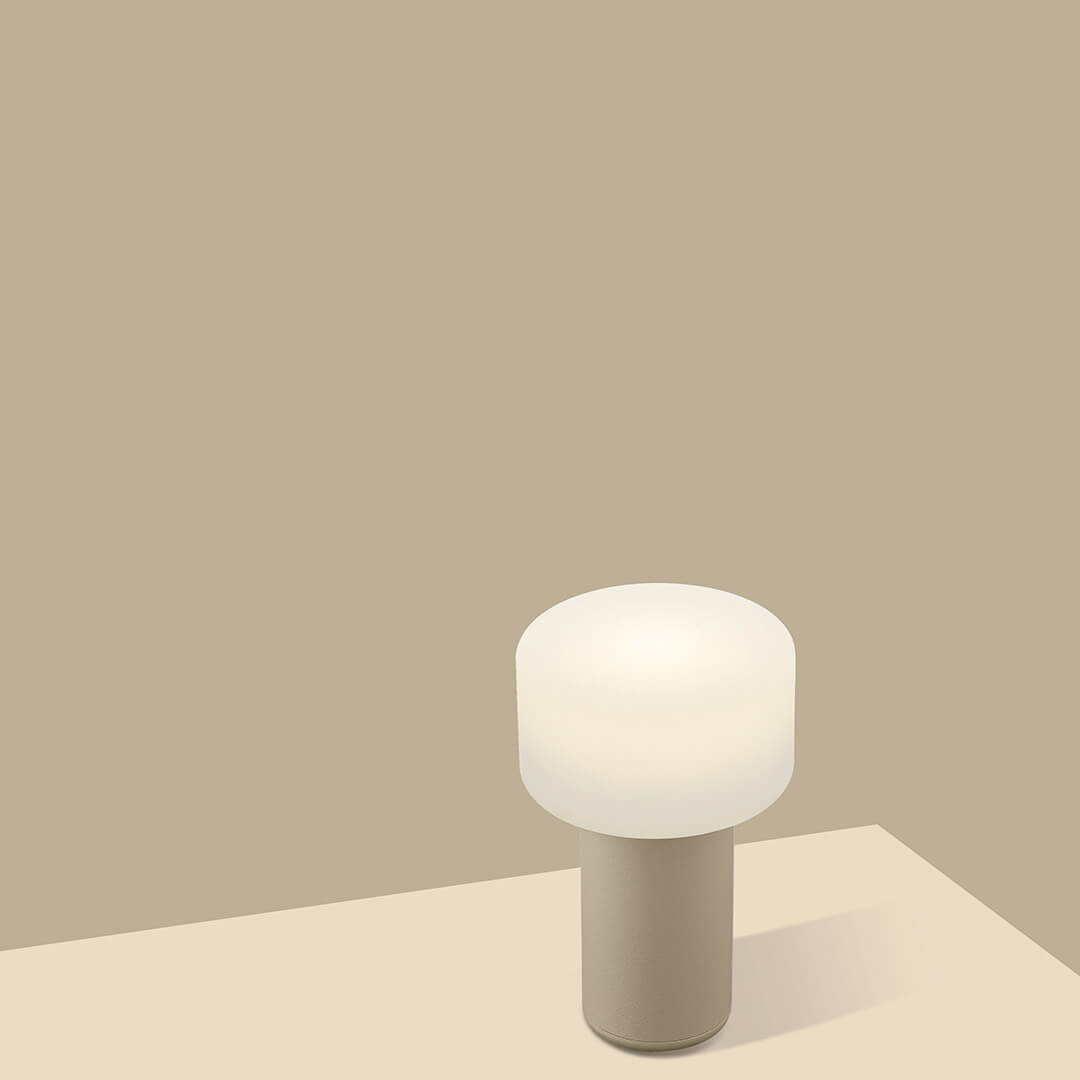 Lampe allumée posée sur un plan beige clair, ambiance douce et minimaliste