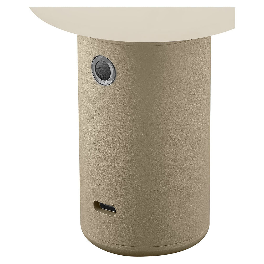Gros plan sur la base : bouton rond, port USB-C et texture sable