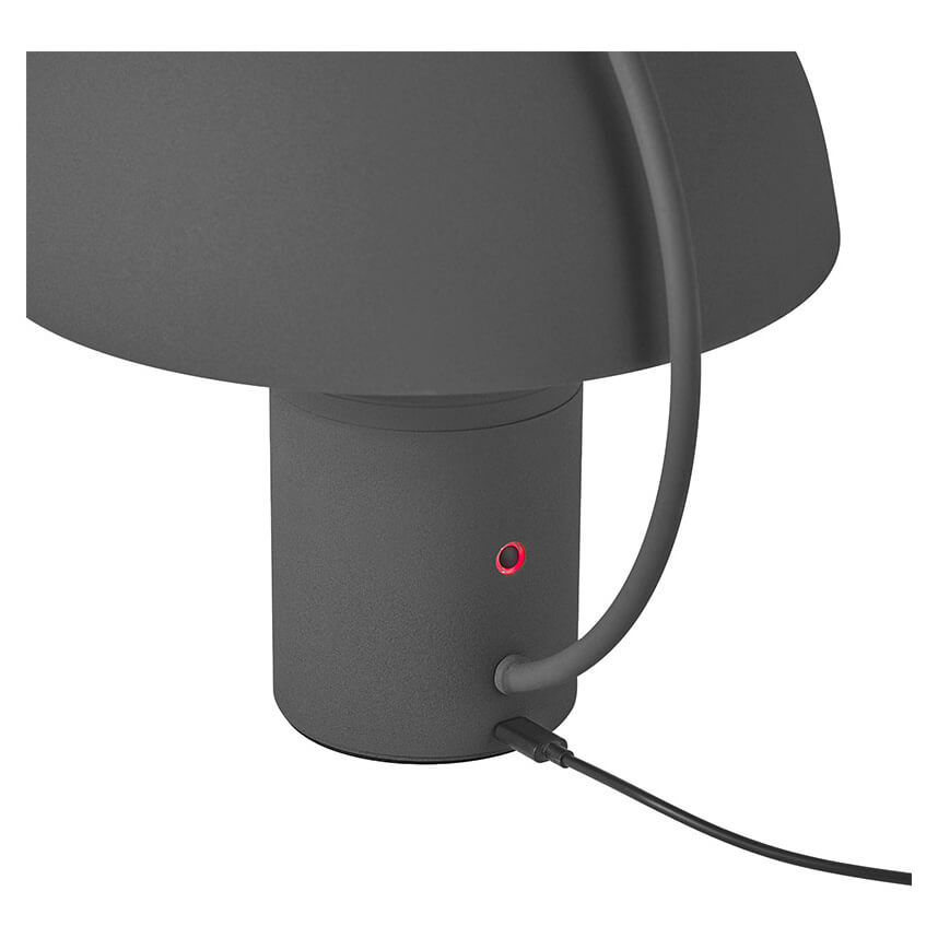 Détail du socle avec bouton rouge et câble d'alimentation branché.