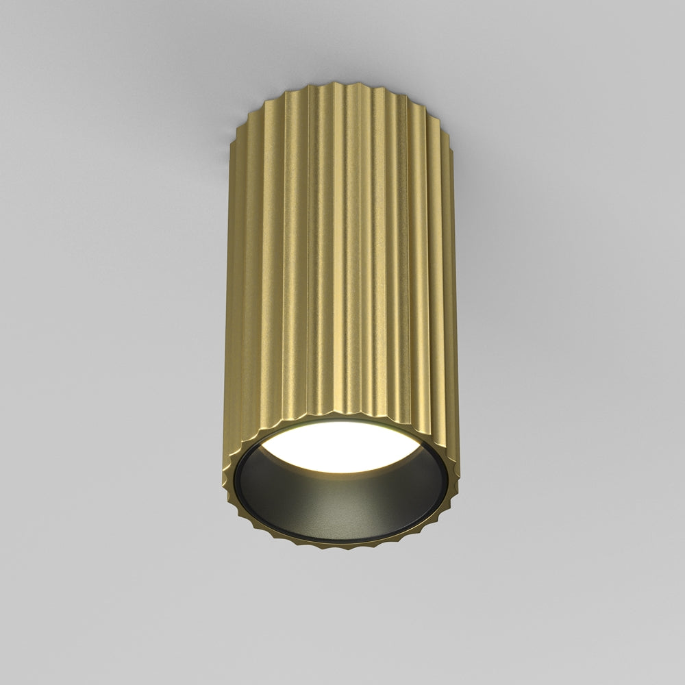 Vue de face du spot cylindrique doré à stries verticales, monté au plafond