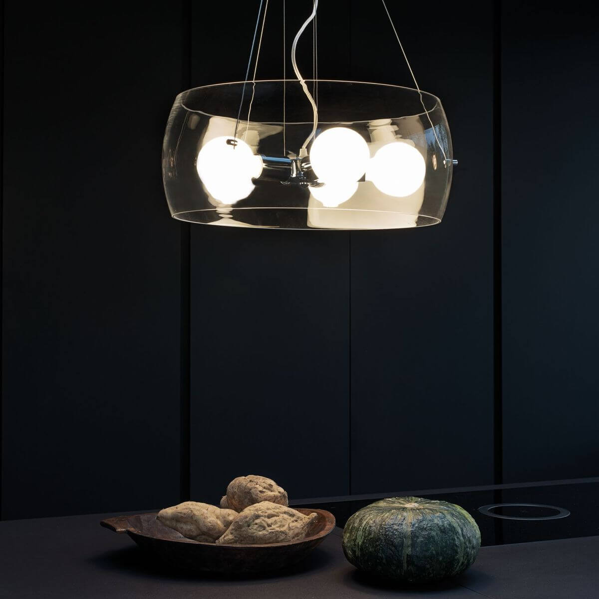 Mise en ambiance dans une cuisine sombre avec pain et courge sur le plan de travail