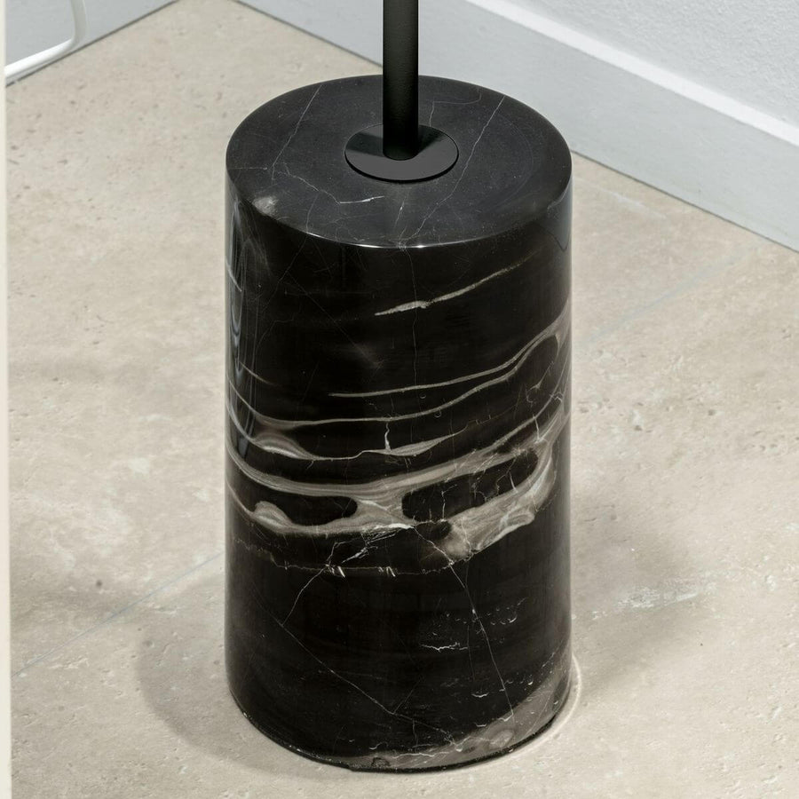 Gros plan sur la base cylindrique en marbre noir aux veines blanches