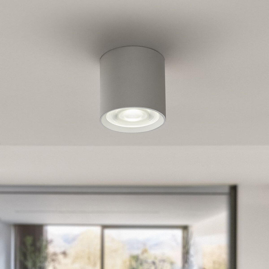 Gros plan du plafonnier blanc allumé, détail du diffuseur en verre