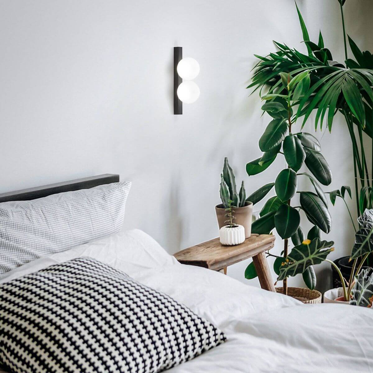 Mise en ambiance de l applique allumée au-dessus d une tête de lit avec plantes