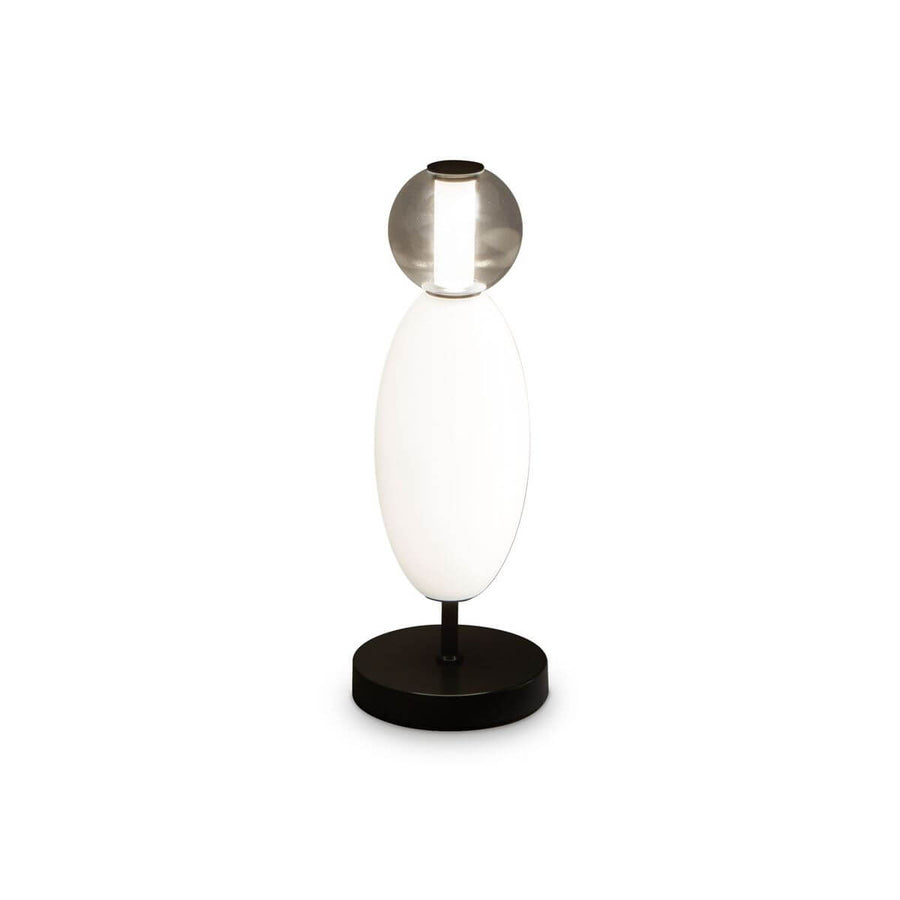 Lampe à poser de face sur fond blanc, corps ovale en verre blanc et sphère fumée.