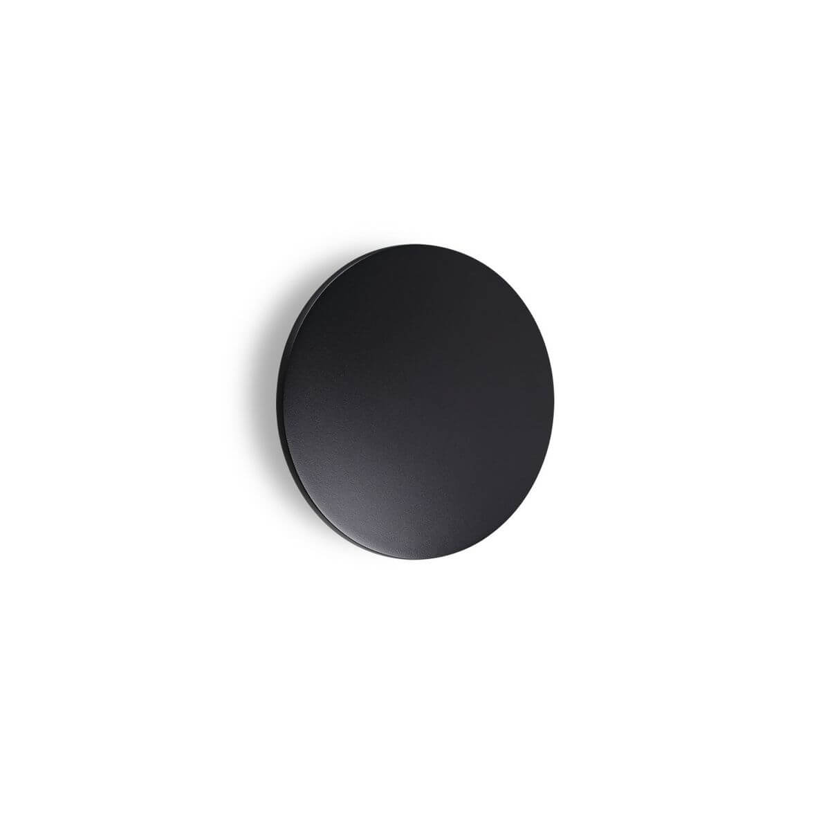 Applique murale ronde noire fixée sur un mur blanc, vue de face