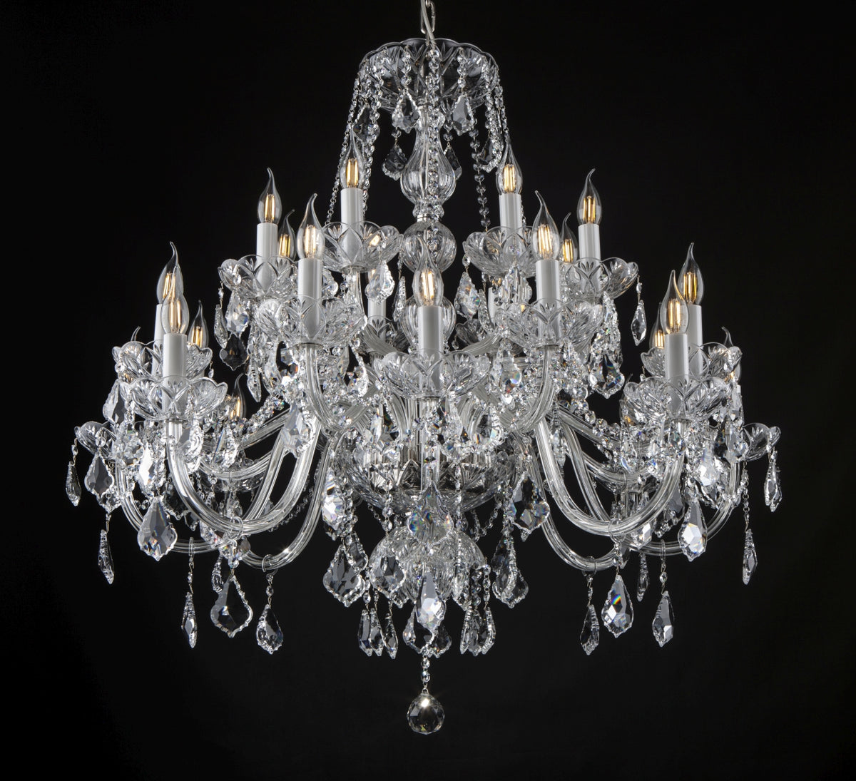 Lustre en cristal à dix-huit bras de lumière, gouttes pendantes, fond noir, vue de face.