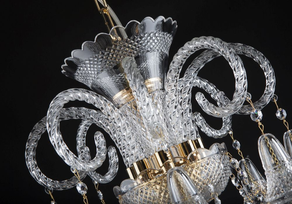 Détail du sommet du lustre avec bras de cristal recourbés et éléments dorés