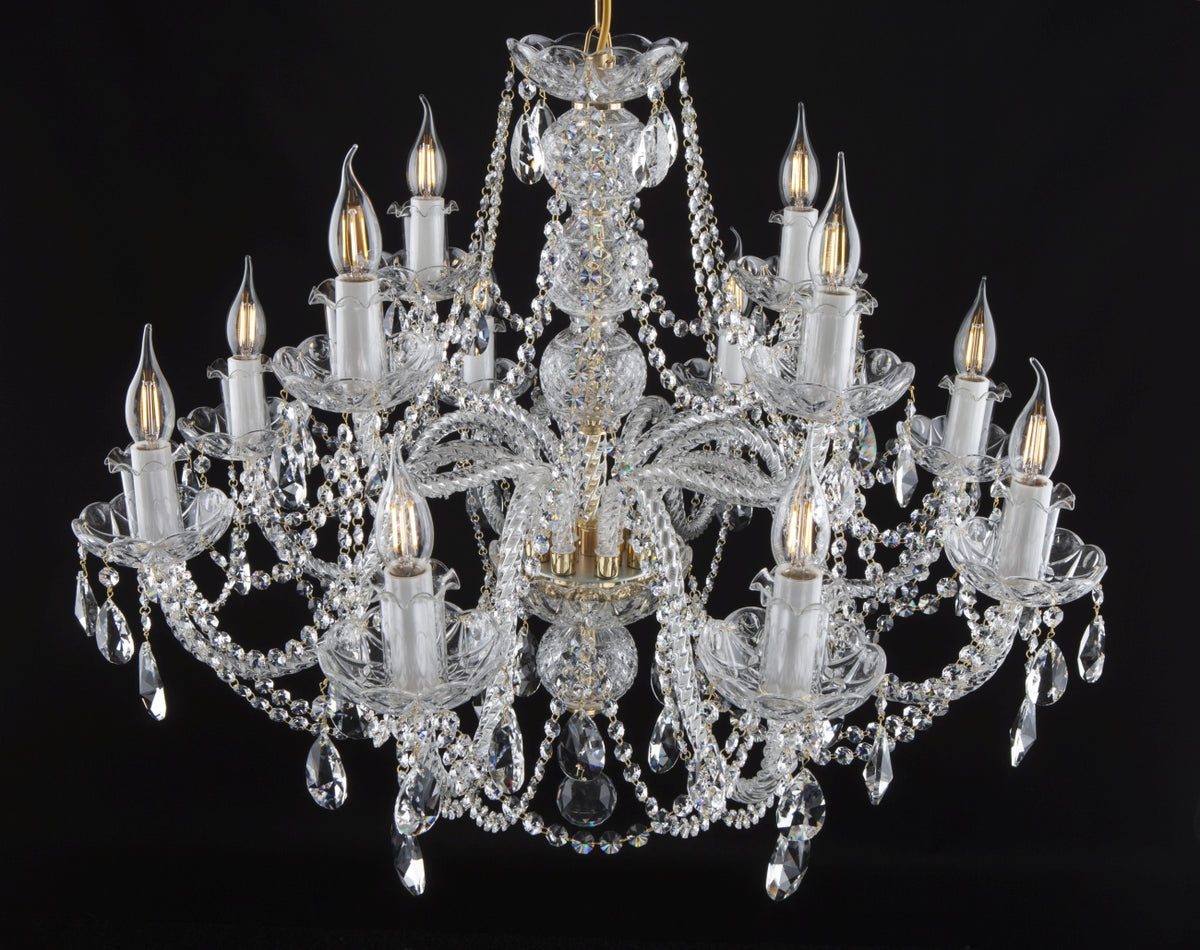 Lustre en cristal à douze bras, vue de face sur fond noir, ampoules allumées