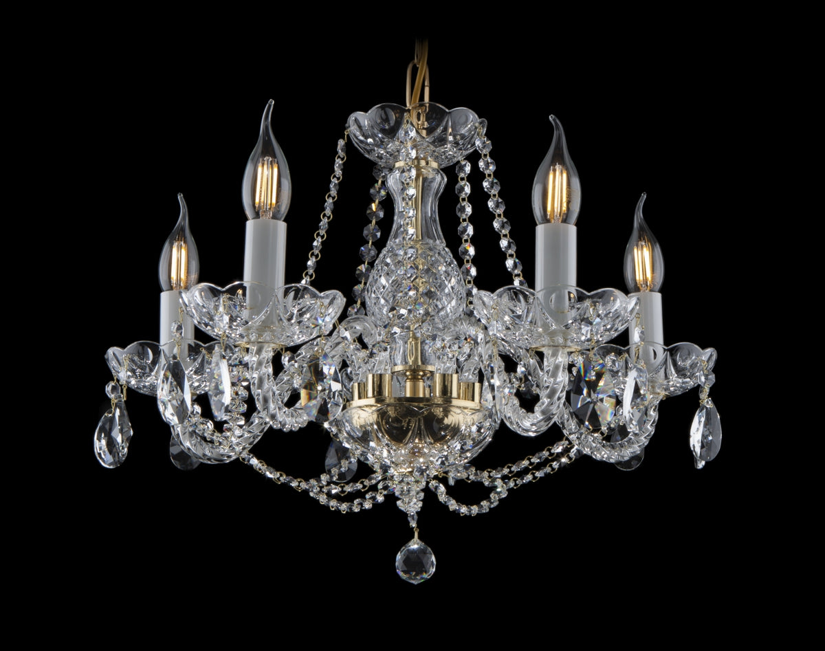 Vue de face sur fond noir, lustre cinq bras en cristal et monture dorée