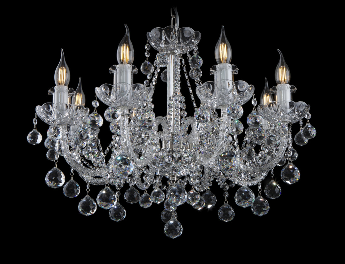 Lustre en cristal à bras recourbés, vue de face sur fond noir.