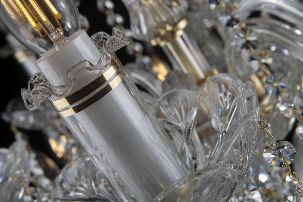 Détail de la douille blanche cerclée d'or sous une ampoule allumée