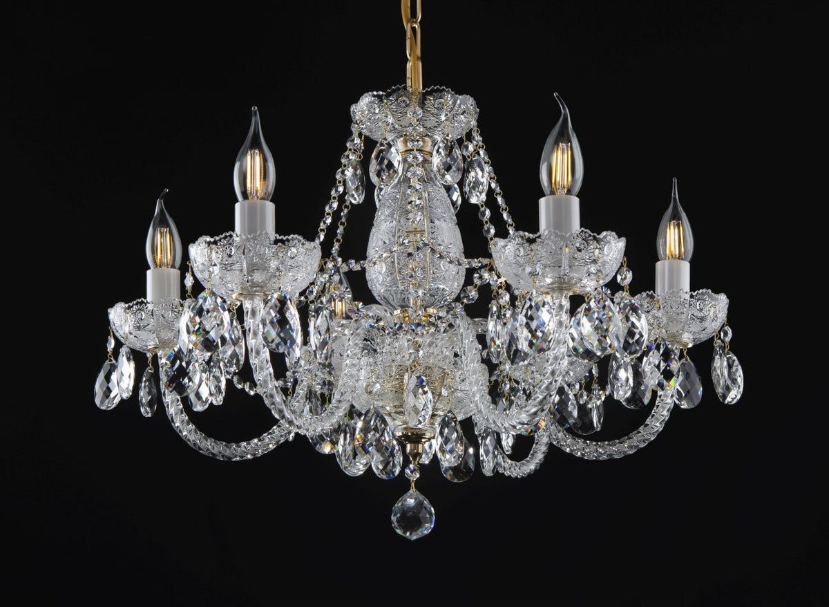 Lustre en cristal à cinq bras dorés présenté de face sur fond noir