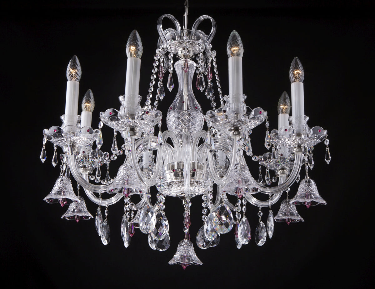 Lustre en cristal à sept bras, suspendu et photographié de face sur fond noir