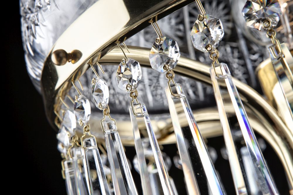 Gros plan sur les pendentifs en cristal et la bague en laiton doré.