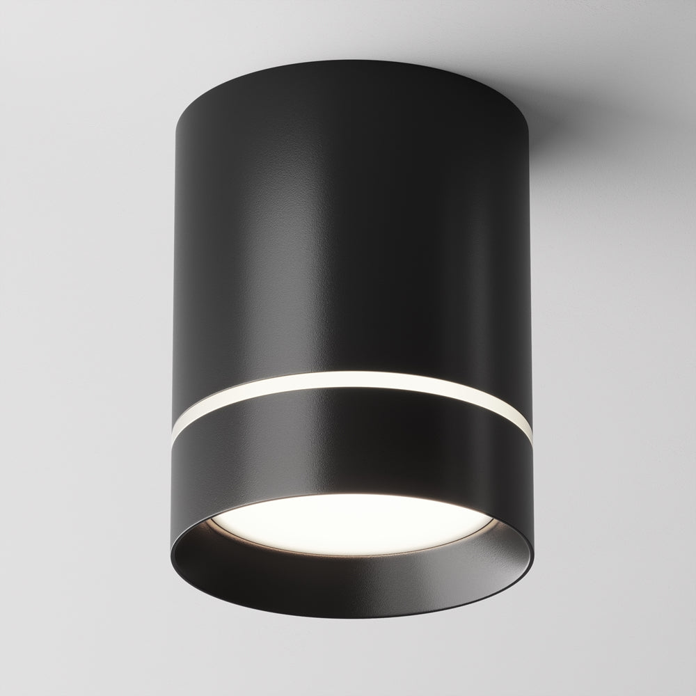 Plafonnier cylindrique noir mat vu de face, bague lumineuse allumée