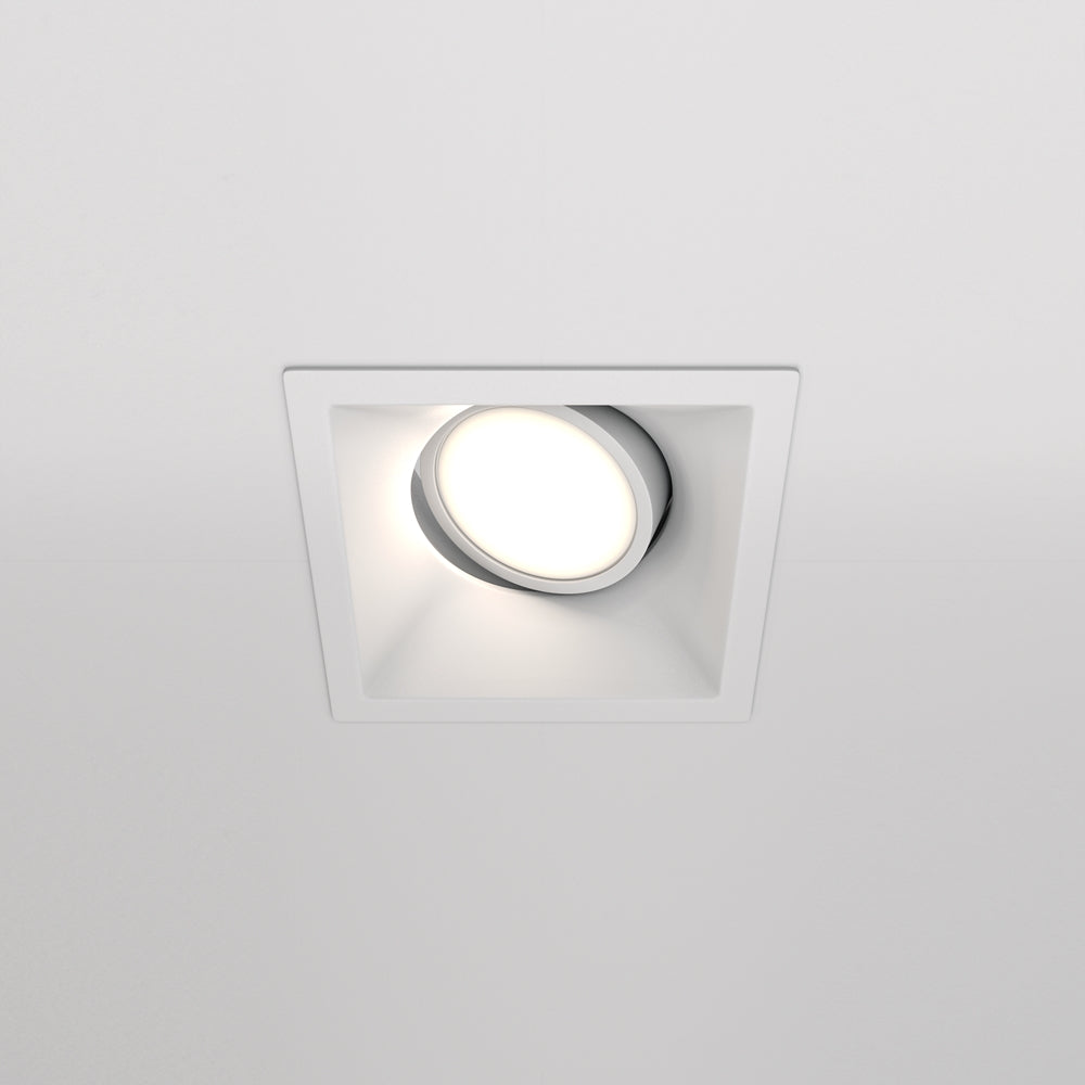 Vue de face d'un spot encastré blanc carré avec diffuseur rond orientable au plafond.