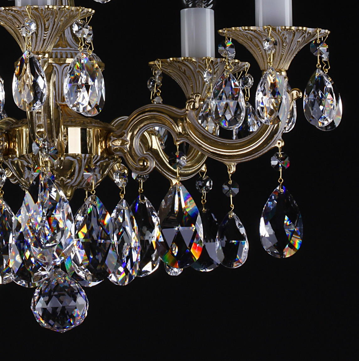 Détail rapproché des bras courbes dorés et des pendants de cristal aux reflets iridescents