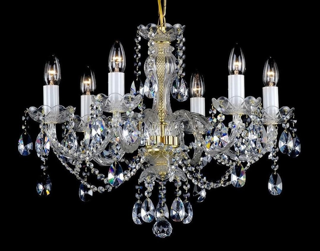 Lustre en cristal à huit bras dorés, pendentifs gouttes et douilles bougies sur fond noir.