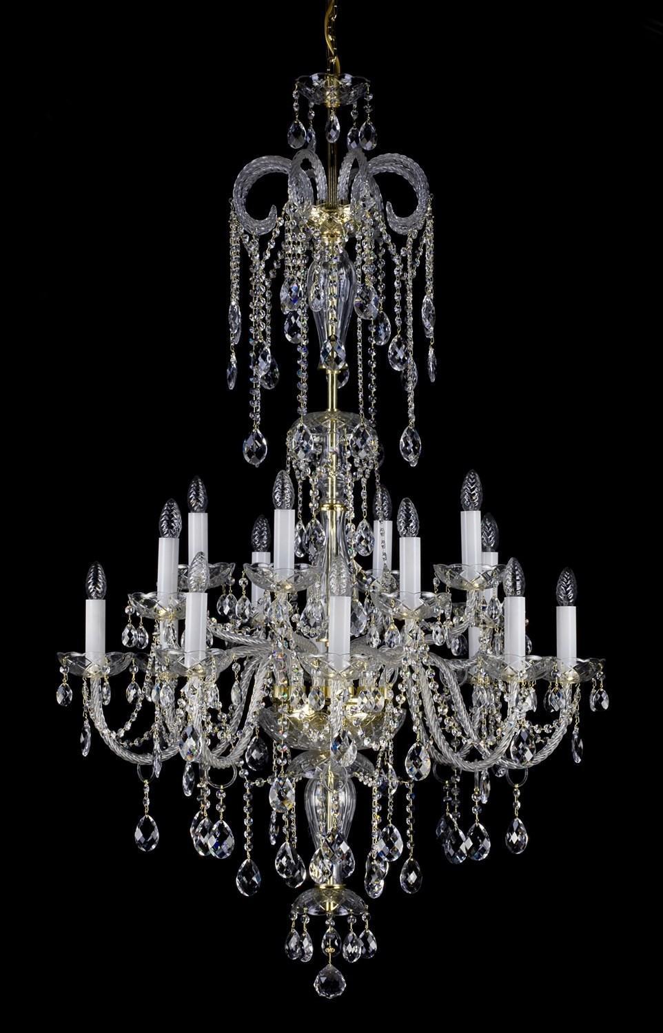 Lustre en cristal photographié de face sur fond noir, bras, bougies et pendeloques visibles
