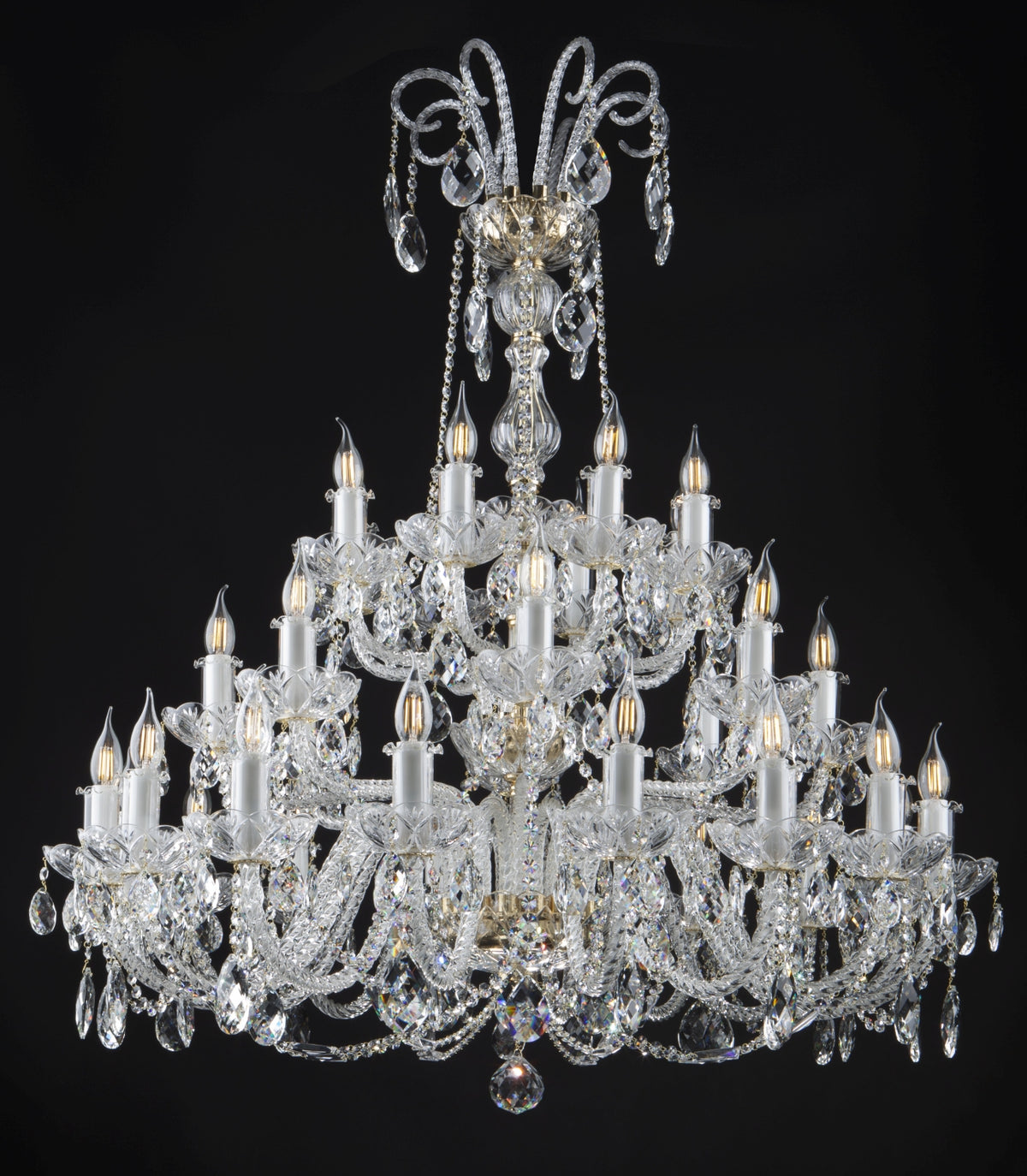 Lustre de face sur fond noir, cristaux taillés et nombreuses bougies allumées