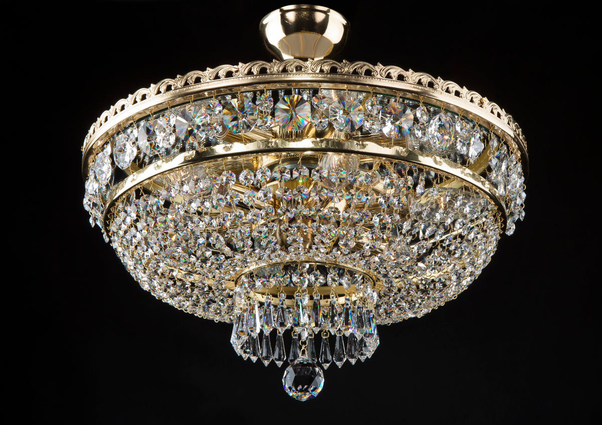Plafonnier corbeille en cristal et laiton doré présenté de face sur fond noir
