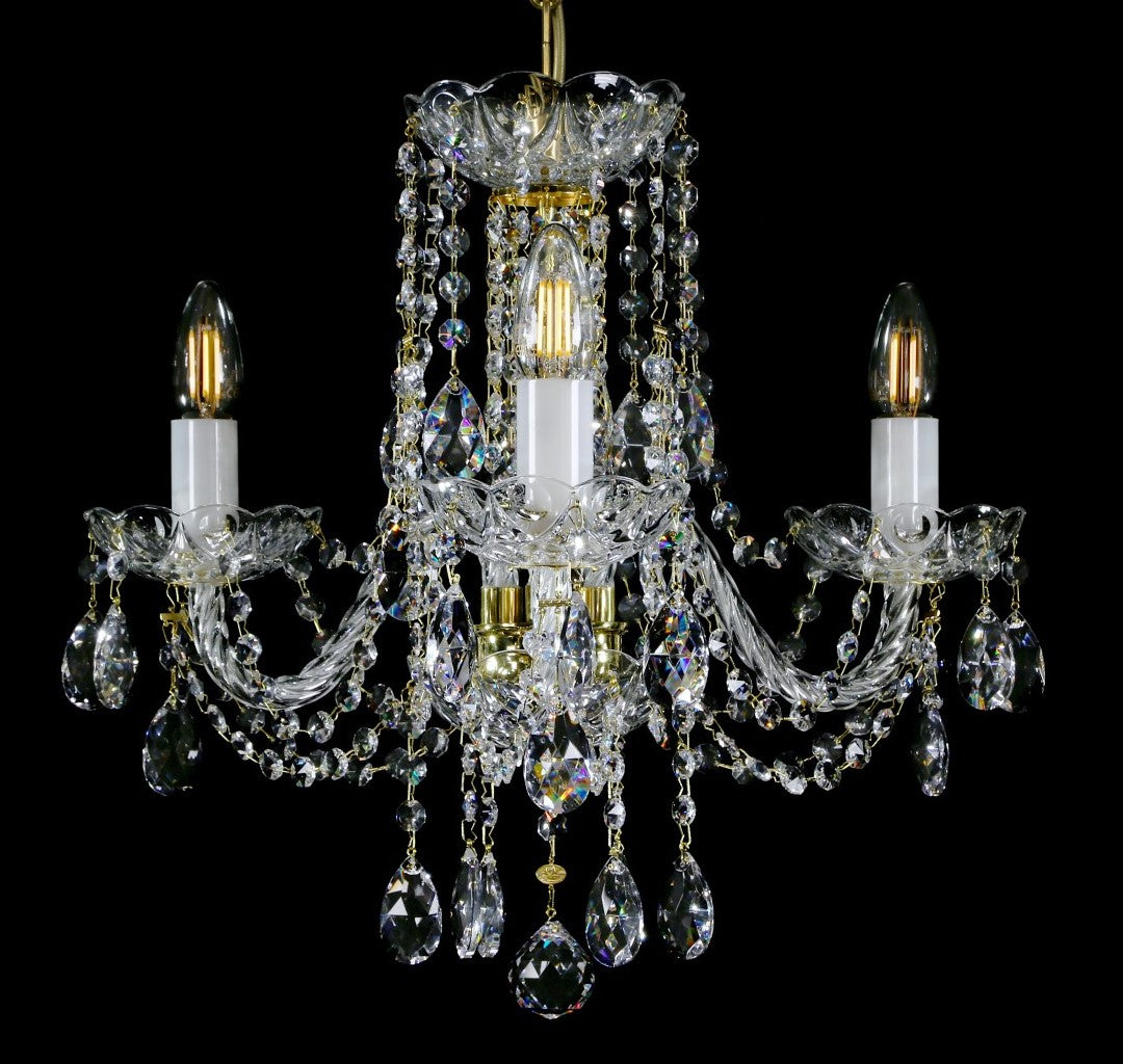 Lustre de cristal à trois bras, pendeloques en gouttes, présenté de face sur fond noir