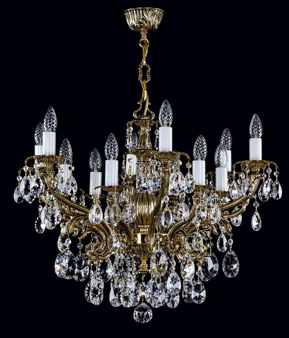 Lustre doré suspendu avec nombreux bras, orné de cristaux taillés en gouttes sur fond noir.